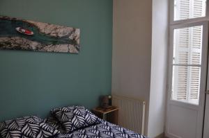 a bedroom with a bed and a painting on the wall at nid douillet 4places 2lits cœur de ville logement Hote-Zen wifi in Segré
