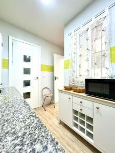 a bedroom with a white dresser with a tv on it at Rosaleda Centro Apartamento in Málaga