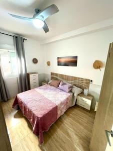 a bedroom with a bed and a ceiling fan at Rosaleda Centro Apartamento in Málaga