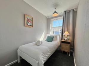 a bedroom with a white bed and a window at Wonderful Oxford Jericho 3 Bedroom House with Parking and Private Garden in Oxford