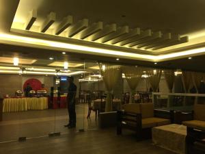 Ein Mann, der mitten in einem Restaurant steht in der Unterkunft Neeshorgo Hotel & Resort in Cox's Bazar