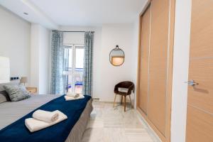 sypialnia z łóżkiem, krzesłem i oknem w obiekcie Triana Betis w Sewilli