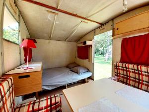 a room with a bed and a table in a caravan at Caravane vintage in Pornichet