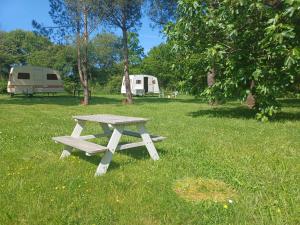 a picnic table in the grass next to a trailer at Caravane vintage in Pornichet +7 photos