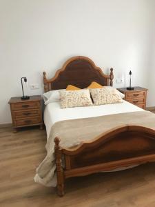 a bedroom with a large wooden bed and two night stands at O Fogar do Moucho - Tres Marias Apartments in Redondela