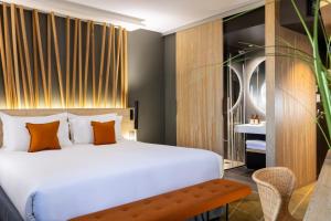 a bedroom with a large white bed and a bench at Belaroïa Montpellier Centre Saint Roch in Montpellier +49 photos