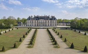 a large building with a pathway in front of a field at Agréable maison familiale in La Louptière-Thénard