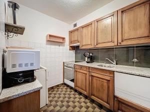 a kitchen with wooden cabinets and a microwave at Chottelaine 002 in Verbier