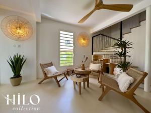 a living room with chairs and a spiral staircase at HILO Villa Lagon de l'Hermitage Nomade in L'Ermitage-Les-Bains
