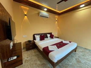 una camera da letto con un letto grande e una televisione di Coral Cove Resort, Nagaon a Nagaon Altre 15 foto