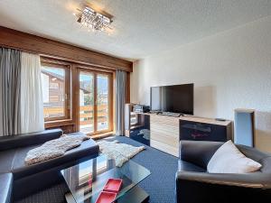 a living room with a couch and a television at Chottelaine 002 in Verbier