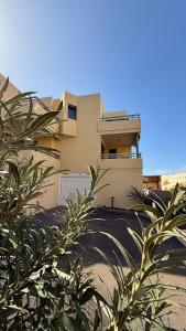 un edificio con palme di fronte di SUN & SURF Tejita a El Médano