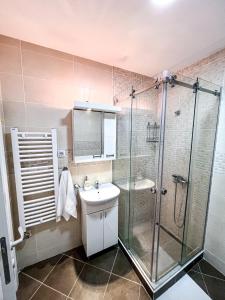 a bathroom with a glass shower and a sink at Limpio Apartman in Belgrade +42 photos