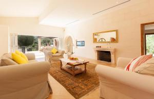 Una sala de estar con sofás y chimenea. en Villa Can Marina, en Pollensa