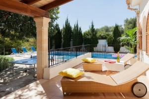 Un patio con mesa y sillas y una piscina. en Villa Can Marina, en Pollensa