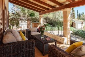 un patio con sillas de mimbre y una mesa en un porche en Villa Can Marina, en Pollensa