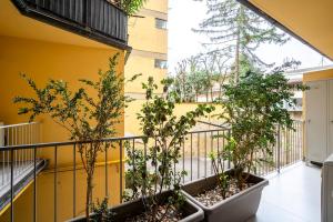 a balcony with trees and a yellow wall at NEW - 2 Min Metro Batoni - Luxury Apt con Posto Auto in Florence