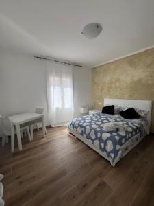 a bedroom with a bed and a table and a desk at La Casa del Giglio in Albenga
