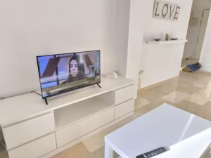una sala de estar con TV de pantalla plana en una cómoda blanca en Elviria, en Marbella
