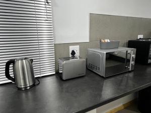 a kitchen counter with a microwave and a toaster at Cradock Guest House & Self Catering in Cradock