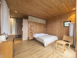 una camera da letto con un letto e una parete di legno di Chunqiu · Banshan Leisure Resort a Chongzhou