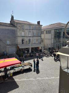 a group of people standing around a street market at Appartement plein coeur de ville in Fontenay-le-Comte