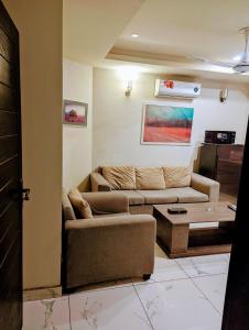 ラーワルピンディーにあるLuxury Apartmentsのソファとテーブルのあるリビングルーム