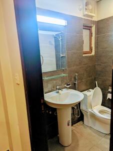 ラーワルピンディーにあるLuxury Apartmentsの白いトイレと洗面台のあるバスルーム