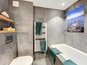 a bathroom with a bath tub and a toilet at Trois Mélèzes 105 in Verbier