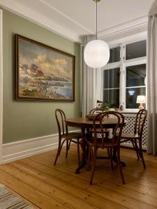 a dining room with a table and chairs and a painting at Hotel Klostergaarden in Allinge +147 photos