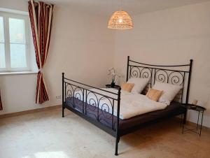 - une chambre avec un lit noir et un lustre dans l'établissement Cottage Living, à Leiblfing