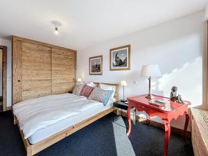 a bedroom with a bed and a red table at Trois Mélèzes 105 in Verbier