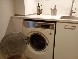 - un lave-linge dans une cuisine à côté d'un évier dans l'établissement Cottage Living, à Leiblfing