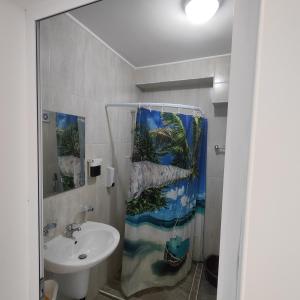 a bathroom with a sink and a shower curtain at апартамент на брега на морето Бургас - Сарафово in Burgas City