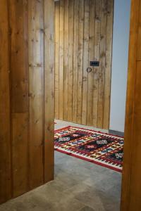 una camera con una parete in legno e una porta con un tappeto di NOOK Kopaonik Luxury Apart & House a Kopaonik