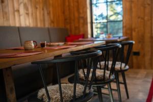 una fila di sgabelli da bar a un tavolo in un ristorante di NOOK Kopaonik Luxury Apart & House a Kopaonik