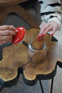 una persona con le mani rosse che stringono un cucchiaio rosso di NOOK Kopaonik Luxury Apart & House a Kopaonik Altre 17 foto