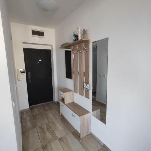 a room with a wooden shelf and a mirror at апартамент на брега на морето Бургас - Сарафово in Burgas City +19 photos