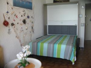 a bedroom with a bed and a rock wall at Studio vue sur la mer au 6ème et dernier étage in Canet-en-Roussillon