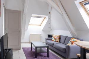 a living room with a couch and a table at immeuble entier ✰ coeur de ville ✰ terrasse balcon in Segré