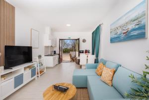 a living room with a blue couch and a tv at Apartment FraNiTo #2 - Stylish Apartment close to Dubrovnik in Mlini
