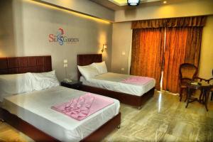 a hotel room with two beds with pink sheets at La mer Hotel in Alexandria