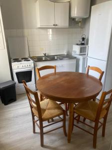 a kitchen with a wooden table and chairs in it at Appartemment T3 (2 chambres) cœur de Candé WIFI in Candé +3 photos