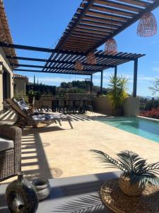 un patio con piscina y pérgola en Villa vue sur Draguignan, en Draguignan