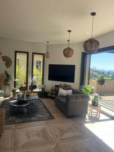 Una sala de estar con un sofá y un televisor de pantalla plana. en Villa vue sur Draguignan, en Draguignan