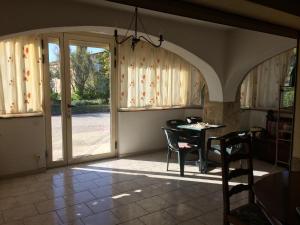 a dining room with a table and chairs and sliding glass doors at Chez Laurette in Mirabel-aux-Baronnies