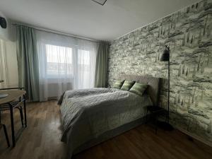 a bedroom with a bed and a stone wall at Apartmán MEDIK in Martin