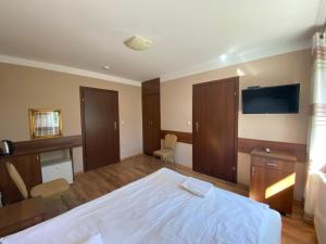 a bedroom with a bed and a flat screen tv at Ośrodek Wypoczynkowy WULPINK in Majdy