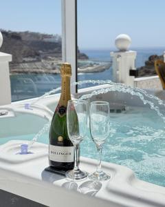 Una botella de champán y dos copas de vino en una bañera. en Bella Vista - Jacuzzi with amazing sea views, en Playa del Cura
