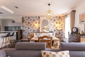 a living room with a dining table and a kitchen at Villa de la Salmonière - Maison avec piscine et jardin clos in La Roche-Blanche